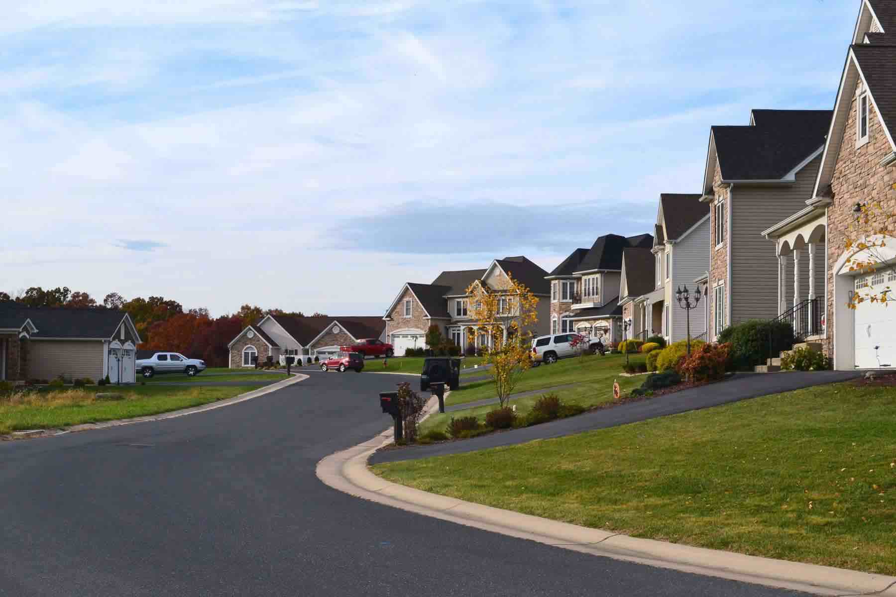 Suburban neighborhood street view of multiple houses at sunset