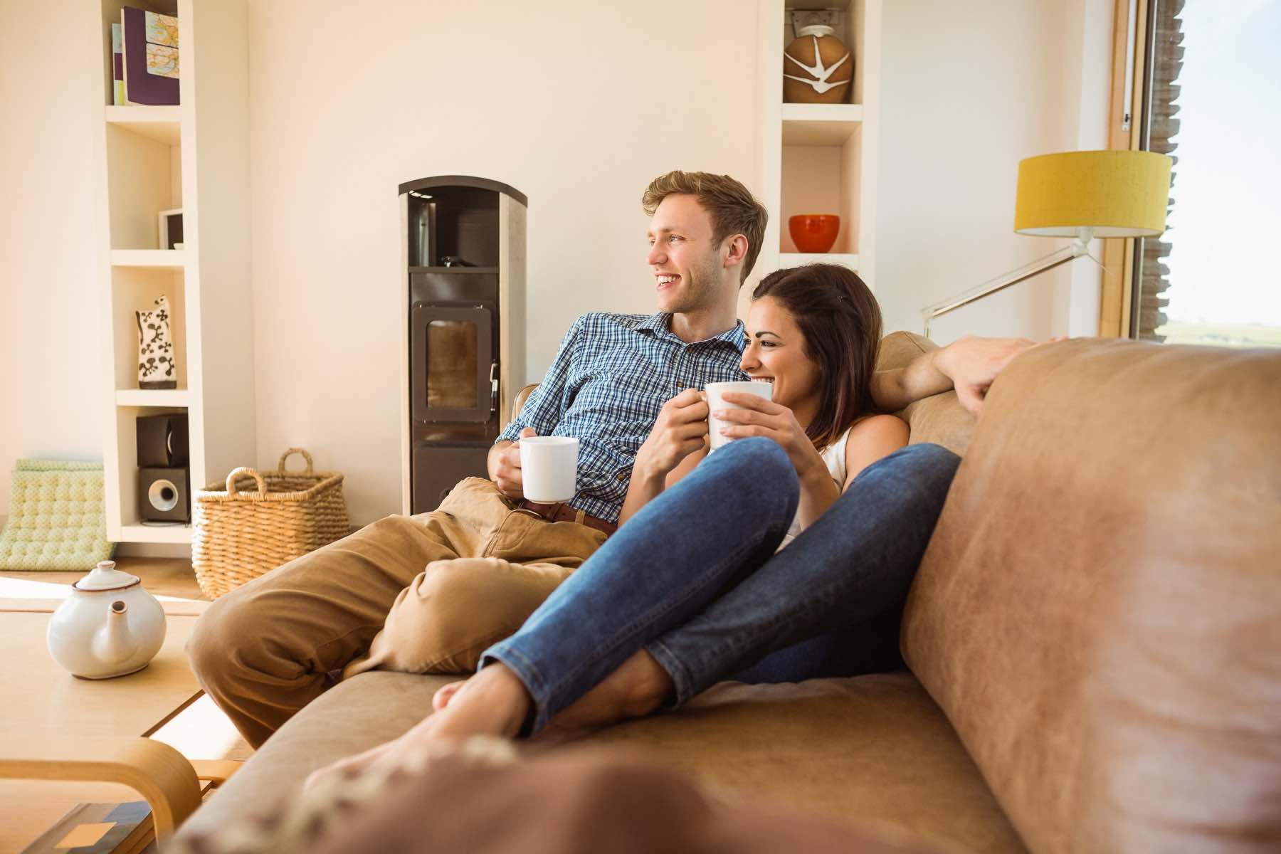 Happy young couple relaxing on the couch at home in the living room